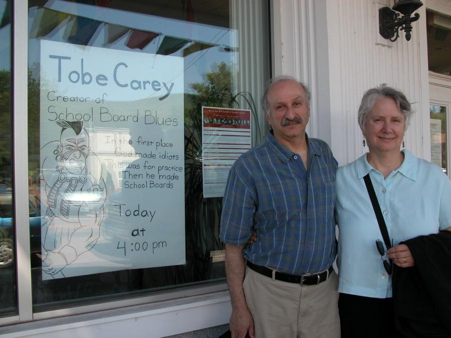 Tobe and Meg Carey outside Hunter Cinema, beside a flyer reading 'Tobe Carey, Creator of School Board Blues'