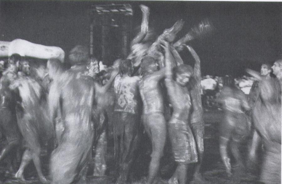 A crowd of mud-covered festivalgoers moshing at Woodstock '94